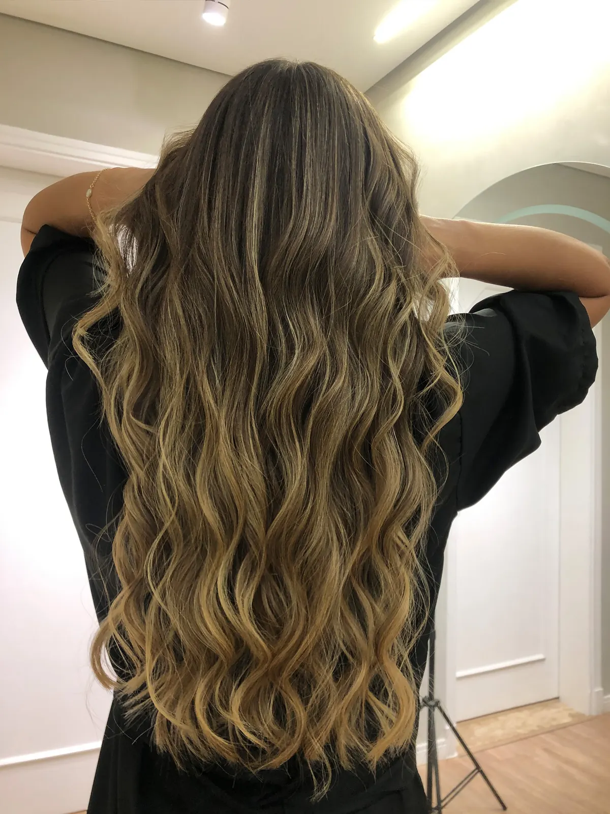 Depois: cabelo longo ondulado com mechas iluminadas