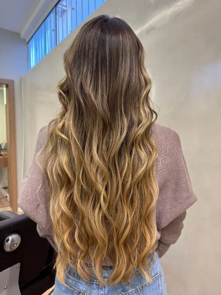 Cabelo longo com mechas loiras e ondas, feito por Caroline Ebling